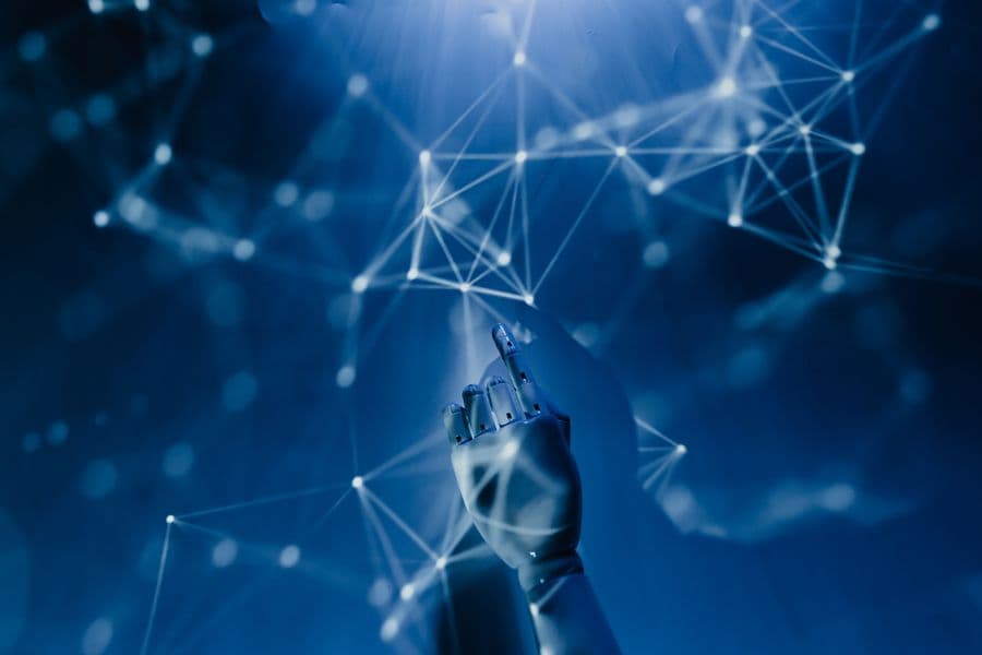 Robotic hand reaching into a glowing blue data network