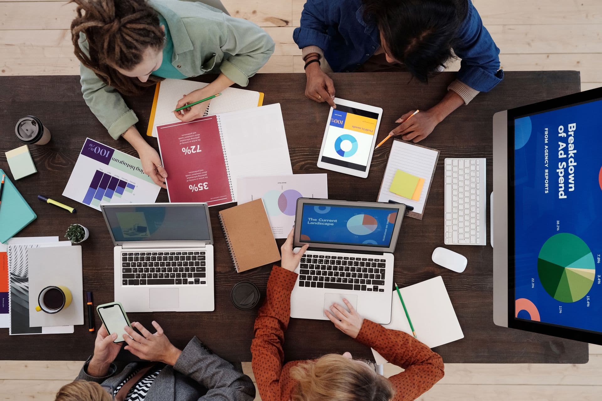 Marketing team reviewing charts and dashboards around a shared desk
